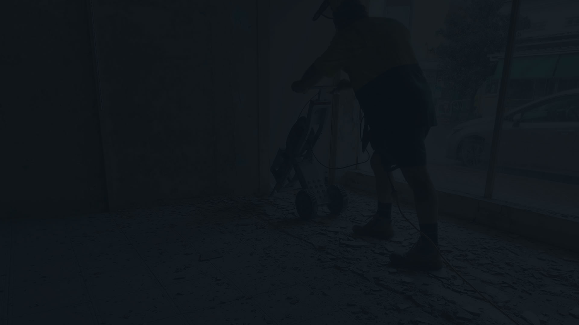 Black Bacground with a silhouette of a man removing tiles on the floor